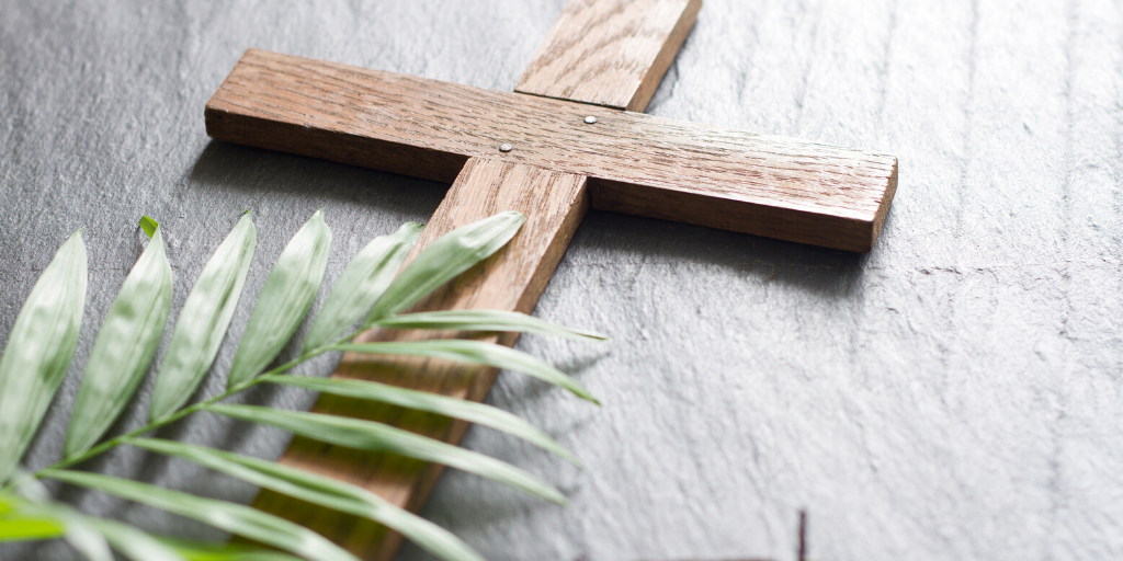 cross and palm frond on a table
